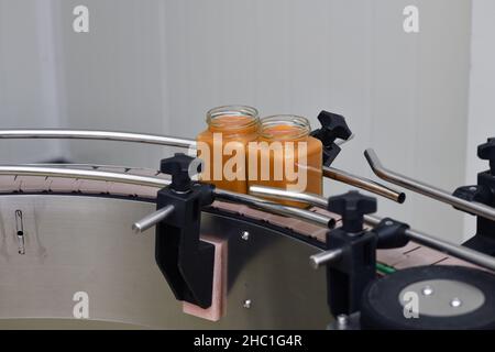 Vasetti di miele cremato in una linea di confezionamento presso una fabbrica commerciale di miele Foto Stock