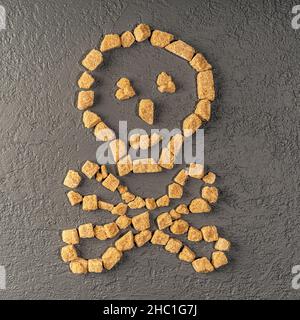 Zucchero di canna sotto forma di cranio e ossa. Avvertimento che zucchero e dolci sono pericolosi per la salute. Il cranio è rivestito di zucchero non raffinato. Selettivo Foto Stock