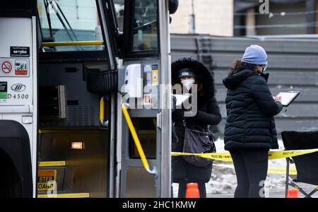 (211221) -- MISSISSAUGA (CANADA), 21 dicembre 2021 (Xinhua) -- i membri del personale aiutano le persone a registrarsi al di fuori di una clinica mobile di vaccini a Mississauga, Ontario, Canada, il 21 dicembre 2021. Il Canada ha segnalato 9.597 nuovi casi COVID-19 martedì pomeriggio, portando il totale cumulativo a 1.907.180 casi con 30.082 morti, secondo CTV. (Foto di Zou Zheng/Xinhua) Foto Stock