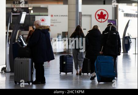 (211221) -- MISSISSAUGA (CANADA), 21 dicembre 2021 (Xinhua) -- viaggiatori che indossano maschere facciali sono visti alla sala partenze dell'aeroporto internazionale Pearson di Toronto a Mississauga, Ontario, Canada, il 21 dicembre 2021. Il Canada ha segnalato 9.597 nuovi casi COVID-19 martedì pomeriggio, portando il totale cumulativo a 1.907.180 casi con 30.082 morti, secondo CTV. (Foto di Zou Zheng/Xinhua) Foto Stock