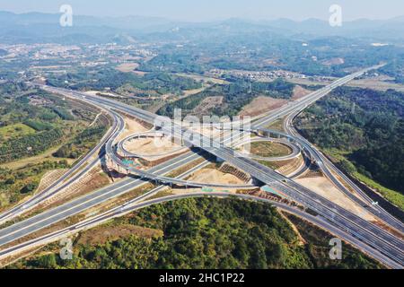 (211219) -- QINGYUAN, 19 dicembre 2021 (Xinhua) -- Foto aerea scattata il 19 dicembre 2021 mostra le interscambiazioni di Sanfengli della Guanglian Expressway sulla Shanzhan Expressway nel distretto di Qingcheng di Qingyuan, nella provincia cinese meridionale di Guangdong. La Guangzhou-Lianzhou Expressway inizia dal distretto di Huadu di Guangzhou e termina nella città di Lianzhou di Qingyuan, collegando con la Yueyang-Linwu Expressway di Hunan. Il progetto principale sarà aperto al traffico entro la fine del 2021. Dopo il completamento, migliorerà ulteriormente il corridoio interprovinciale tra Guangdong e Hunan e promuoverà l'integrazione del mountai Foto Stock