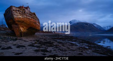 Il relitto di Corpach, conosciuto anche come la vecchia barca di Caol a Loch Eil vicino a Fort William, Scozia, con la neve coperta BenNevis sullo sfondo. Foto Stock