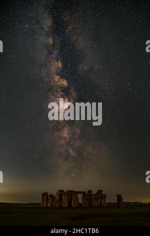 La Via Lattea che sorge sopra l'iconico cerchio di pietra neolitico di Stonehenge sulla piana di Salisbury nel Wiltshire, Regno Unito Foto Stock