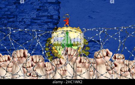 Filo spinato sullo sfondo della bandiera inflitta dello Stato del Vermont e dei fisti rialzati Foto Stock