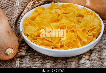 Ciotola di pasta di butternut cucinata su tavola rustica Foto Stock