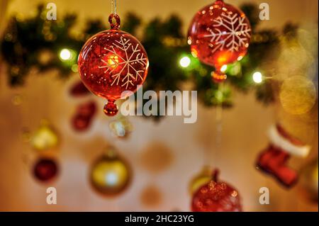 Decorazioni natalizie con baubles rosso e oro. Il bauble rosso sul lato sinistro è messo a fuoco. Foto Stock