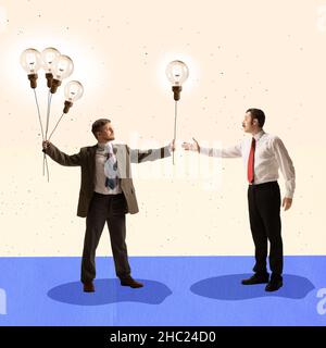 Design moderno e creativo. Uomo d'affari che dà un altro uomo lampadina che simboleggia la parte delle idee e delle conoscenze Foto Stock