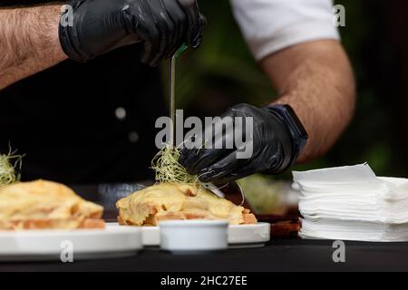 Francesinha, panino tradizionale portoghese originario di Porto. Concetto di cucina nazionale. Lo chef prepara un piatto al ristorante Foto Stock