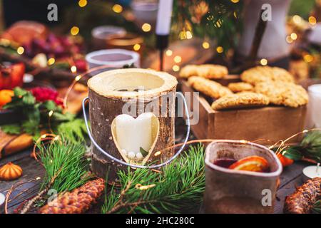 Tavolo per una cerimonia di nozze in stile ecologico nella foresta. Decorazione con fiori freschi, candele, muschio, ghirlande. Tavolo da pranzo in stile boho. V Foto Stock