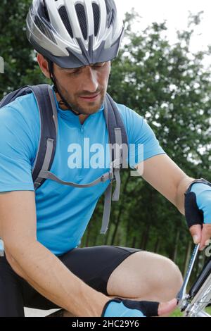 dado di serraggio del ciclista maschio sulla ruota della bicicletta Foto Stock