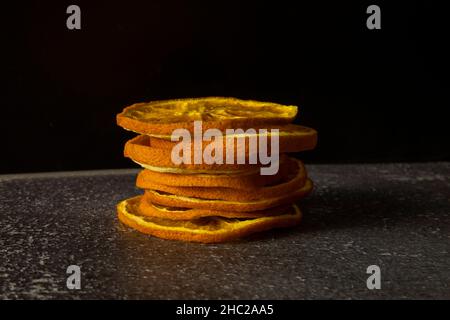 Arance secche su sfondo scuro Foto Stock