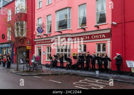 Clonakilty, West Cork, Irlanda. 23rd Dic 2021. La Clonakilty Brass Band ha giocato i caroli di Natale su Clonakilty Main Street oggi, il giorno prima della vigilia di Natale, che ha tirato una grande folla di spettatori. Credit: AG News/Alamy Live News Foto Stock