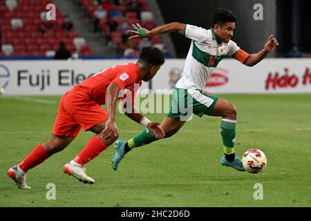 (211223) --, 23 dicembre 2021 (Xinhua) -- Mangkualam Asnawi Bahar (R) dell'Indonesia compete durante l'ASEAN Football Federation (AFF) Suzuki Cup 2020 semi-finale prima tappa tra Singapore e Indonesia allo Stadio Nazionale di Singapore il 22 dicembre 2021. (Foto di allora Chih Wey/Xinhua) Foto Stock