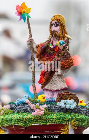 Londra, Regno Unito. 23 dicembre 2021. Un topper colorato in maglia chiamato 'St Christopher, Patron Saint of Travellers', 2021, di Karin Lighthouse, si trova in cima a una casella postale a Northwood, a nord-ovest di Londra, parte di una tendenza in corso decorando Royal Mail caselle postali. Creati dai cosiddetti “bombardieri del filato”, i disegni uncinati di lana sono spesso collocati anonimamente e registrano eventi locali, festosi o newsworthy, compresa la pandemia in corso. Credit: Stephen Chung / Alamy Live News Foto Stock