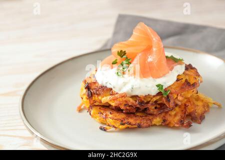 Frittelle di antipasti di patate e kuri rosso squash con salsa di curd alle erbe e salmone affumicato per il Ringraziamento, Natale e Capodanno su un piatto grigio, copia Foto Stock