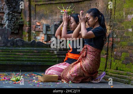 Le giovani donne prendono parte ad una cerimonia religiosa a Bali, Indonesia Foto Stock