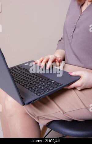 Imprenditrice digitando su laptop al lavoro donna che lavorano in ufficio a casa la tastiera a mano Foto Stock