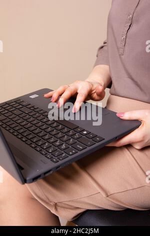 Imprenditrice digitando su laptop al lavoro donna che lavorano in ufficio a casa la tastiera a mano Foto Stock