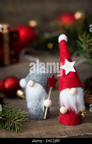 Concetto di Natale. Biglietto di Natale con gnomes, abete, luci di natale e decorazioni su un rustico sfondo di legno. Foto Stock