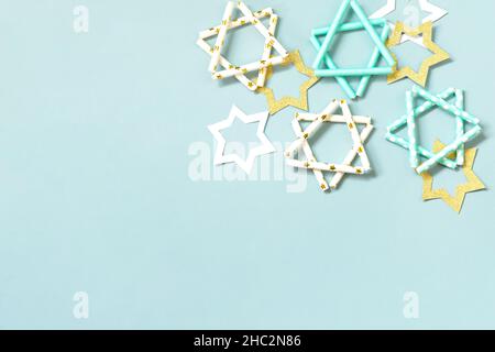 Festa ebraica Hanukkah. Simbolo di Hanukkah stella di David su uno sfondo blu. Vista dall'alto, disposizione piatta. Spazio di copia. Foto Stock