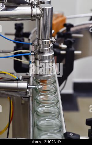 Vasetti di miele cremato in una linea di confezionamento presso una fabbrica commerciale di miele Foto Stock