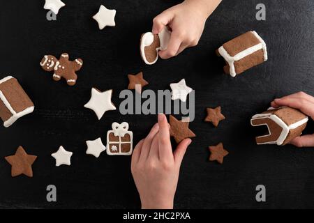 Vista dall'alto: Le mani dei bambini tengono biscotti fatti in casa. Dolci di Capodanno. Foto Stock