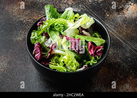 Fregio, insalata di lattuga romaine e Radicchio, su un vecchio sfondo rustico scuro Foto Stock