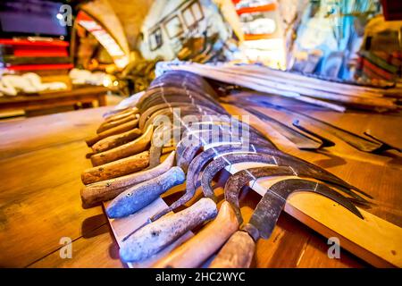 MEDZHYBIZH, UCRAINA - 13 LUGLIO 2021: Esposizione con fila di vecchi falchi arrugginiti in Holodomor (Grande carestia) Museo nel castello di Medzhybizh, il 13 luglio in Foto Stock