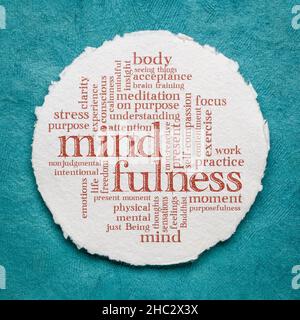 mindfulness parola nuvola - scrittura a mano su un foglio di carta rotonda acquerello Foto Stock