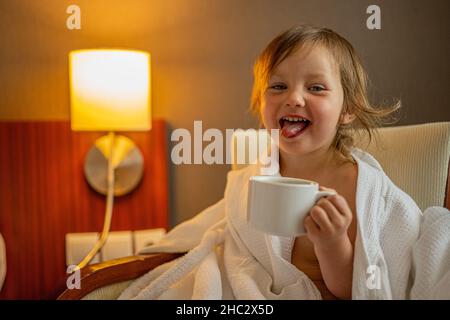 Ritratto di una ragazza carina che beve il tè in una camera da letto. Foto Stock