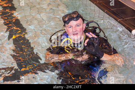 Dave Thompson MBE DL MBA, Chief Executive della Warrington Disability Partnership, indossa attrezzature PER IMMERSIONI che si aggirano per lo Splash for Cash Foto Stock