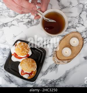 Helsinki / Finlandia - 12 DICEMBRE 2021: Colpo di testa di un piatto con ciambelle tradizionali shrove e un teacup su un piano di granito Foto Stock