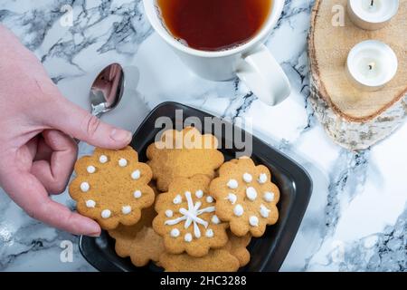 Helsinki / Finlandia - 12 DICEMBRE 2021: Colpo di testa di un piatto con biscotti tradizionali finlandesi fatti in casa di pan di zenzero e un teacup. Foto Stock