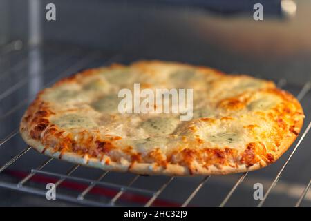 Pizza fatta in casa a quattro formaggi nel forno Foto Stock