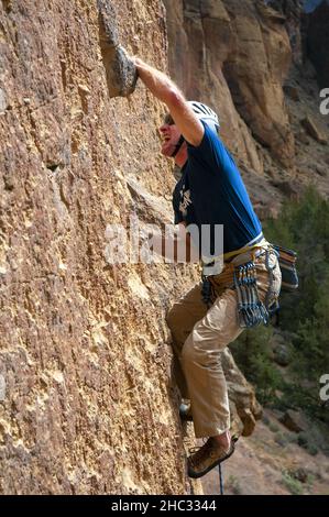 Scalatore di roccia maschile singolo allo Smith Rock state Park. Oregon Foto Stock