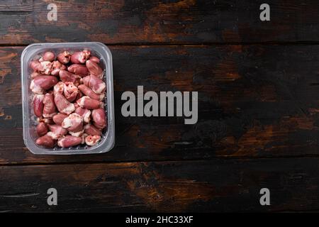 Cuori di tacchino crudo in set di plastica, su vecchio sfondo di legno scuro tavolo, vista dall'alto piatto, con spazio copia per il testo Foto Stock