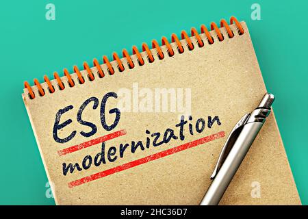 ESG (Environmental, Social, and Corporate Governance): Tema della modernizzazione. Iscrizione ESG Modernization in un blocco note aperto, su sfondo teale Foto Stock