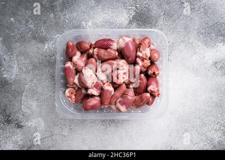 Cuori di tacchino crudi in set di plastica, su sfondo grigio tavolo di pietra, vista dall'alto piatto, con spazio per la copia del testo Foto Stock