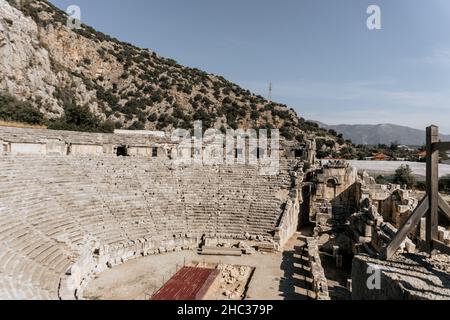 Antico teatro greco a Myra, Turchia. Anfiteatro con le tombe scavate nella roccia della necropoli Licia Foto Stock