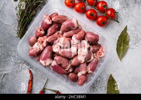 Cuori di tacchino crudo in set di plastica, su sfondo grigio tavolo di pietra Foto Stock