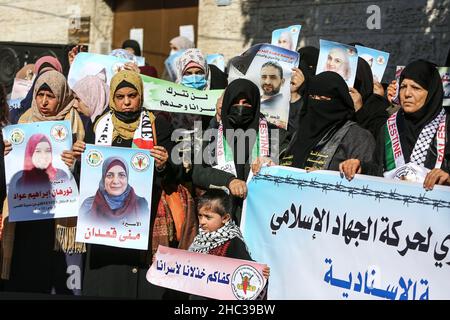 Gaza, Palestina. 22nd Dic 2021. Le donne palestinesi hanno ritratti di prigionieri, durante una dimostrazione di solidarietà con i prigionieri palestinesi all'interno delle prigioni israeliane, di fronte all'edificio della Croce Rossa a Gaza. Credit: SOPA Images Limited/Alamy Live News Foto Stock