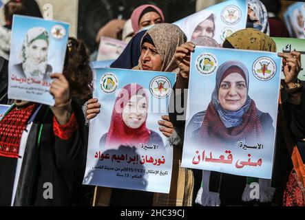 Gaza, Palestina. 22nd Dic 2021. Le donne palestinesi hanno ritratti di prigionieri, durante una dimostrazione di solidarietà con i prigionieri palestinesi all'interno delle prigioni israeliane, di fronte all'edificio della Croce Rossa a Gaza. Credit: SOPA Images Limited/Alamy Live News Foto Stock