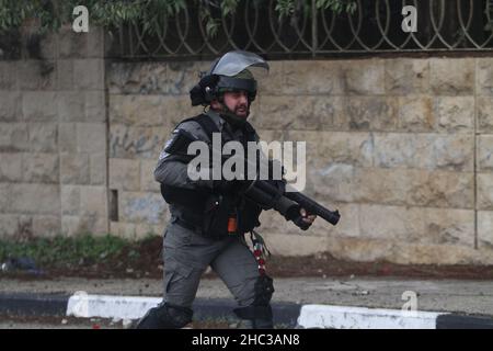 Nablus, Palestina. 23rd Dic 2021. Un soldato israeliano ha visto correre durante la dimostrazione.i palestinesi hanno protestato per la ricostruzione dell'insediamento ebraico di Homesh, che è stato evacuato nel 2007. I coloni israeliani hanno distrutto villaggi, case e automobili palestinesi durante la protesta nel villaggio di Burqa. Credit: SOPA Images Limited/Alamy Live News Foto Stock