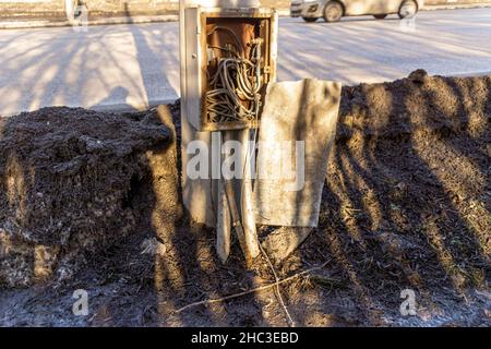 scatola di ferro coperta con fili sul palo dell'illuminazione stradale, cavo di collegamento non autorizzato che esce dalla scatola, messa a fuoco selettiva Foto Stock