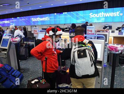 Orlando, Stati Uniti. 23rd Dic 2021. Le persone hanno visto il check-in per il loro volo presso una biglietteria Southwest presso l'aeroporto internazionale di Orlando due giorni prima di Natale.a causa dell'aumento e della diffusione delle infezioni variante di covid-19 e Omicron, i viaggiatori di vacanza stanno prendendo precauzioni supplementari ottenendo testato per il virus prima di riunirsi con la famiglia e gli amici. Credit: SOPA Images Limited/Alamy Live News Foto Stock