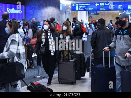 Orlando, Stati Uniti. 23rd Dic 2021. La gente arriva al banco dei biglietti Southwest all'Aeroporto Internazionale di Orlando due giorni prima di Natale.a causa dell'aumento e della diffusione delle infezioni della variante di covid-19 e Omicron, i viaggiatori di vacanza stanno prendendo precauzioni supplementari ottenendo testati per il virus prima di riunirsi con la famiglia e gli amici. Credit: SOPA Images Limited/Alamy Live News Foto Stock