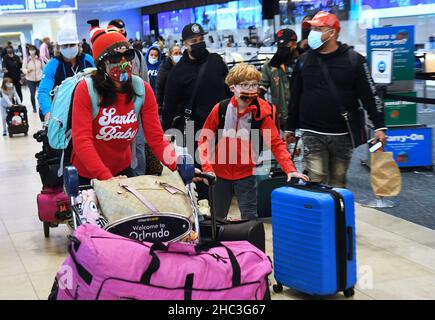 Orlando, Stati Uniti. 23rd Dic 2021. Le persone sono viste con i loro bagagli all'aeroporto internazionale di Orlando due giorni prima di Christmas.a causa dell'aumento e della diffusione di covid-19 e variante di Omicron infezioni, i viaggiatori di vacanza stanno prendendo le precauzioni supplementari ottenendo testato per il virus prima di riunirsi con la famiglia e gli amici. (Foto di Paul Hennessy/SOPA Images/Sipa USA) Credit: Sipa USA/Alamy Live News Foto Stock