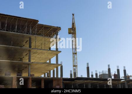 Telai in acciaio di un edificio in costruzione con gru a torre sulla sommità Foto Stock