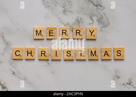 Piastrelle di legno con lettere che formano le parole buon Natale Foto Stock