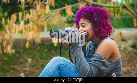 Ragazza che è dedicata alla fotografia si prepara da casa per andare a scattare foto di Foto Stock